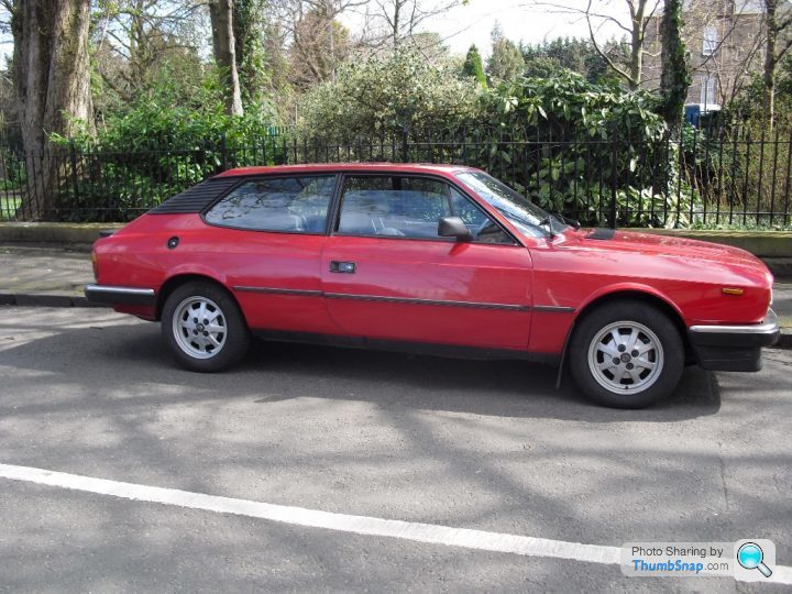 A red car parked in a parking lot - Pistonheads