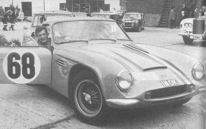 Early TVR Pictures - Page 36 - Classics - PistonHeads - The image is a black and white photograph featuring an old model car with the number 68 painted prominently on its side. The vehicle, possibly an open-topped sports car, appears to be showcased at an auto show, as multiple vintage cars are parked in the background. People are present in the distance, suggesting that this is a public event. The open-top car with the number 68 is the main focus of the image, with its windshield partially lowered to acknowledge the camera. The style of the photograph suggests a historical event captured in monochrome.