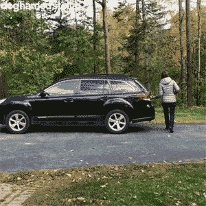 Show us your animated GIFs... [Volume 4] - Page 356 - The Lounge - PistonHeads - The image is a color photograph showing an outdoor setting with a person walking on the road. In the foreground, there is a black SUV parked by the side of the road. The vehicle's interior lighting is visible through the windows, and it has roof racks installed. The surrounding environment includes trees and what appears to be a wooded area in the background. There are no visible texts or distinguishing marks on the image that provide additional context about the location or situation.