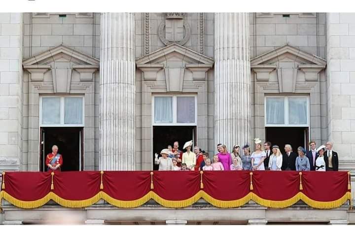 Coronavirus Humour - Page 2 - The Lounge - PistonHeads - The image captures a royal event. A group of people, including members of the royal family, are seated in a balcony overlooking the street below. They appear to be observing an event or parade happening on the street. The balcony has a decorative red and gold curtain that adds to the grandeur of the scene. Behind the balcony, there is a building with classical architecture, featuring columns and a pediment. The overall atmosphere suggests a formal ceremony or celebration.