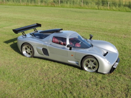 A car is parked on the grass near a field - Pistonheads