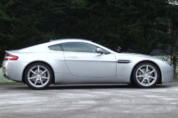 Pistonheads Amv Bought - The image shows a silver, two-door sports car parked near a chain-link fence. The vehicle appears sleek and well-maintained. The design of the car suggests it is a modern sports model, possibly made by a luxury brand. The photo is crisp, with a focus on the car itself, effectively highlighting its details. The surrounding environment has lush greenery, indicating that the car may be parked in a residential or park area.