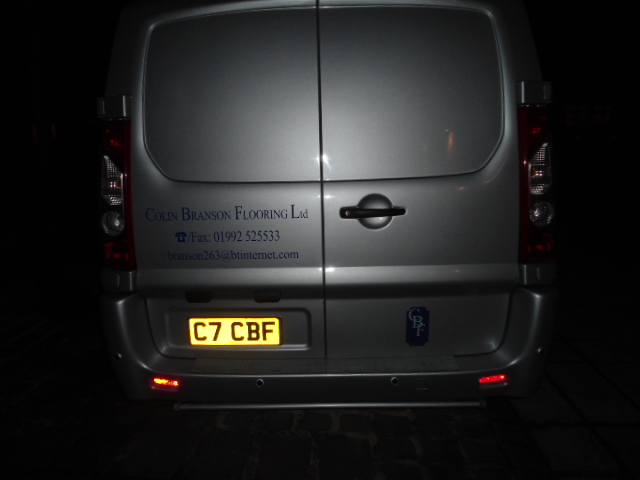 Di*khead of the week award? - Page 1 - Commercial Break - PistonHeads - The image shows a section of a white vehicle under a dark night sky. The vehicle has some decorative decals and text on its rear end. At the top, the left brake light is visible, emitting a red glow. On the right side, the yellow license plate is mounted near a logo of a flower with a c in the center. The text "C7 CBFF" is situated above the license plate, with the numbers "17 22 233" positioned below, indicating a vehicle registration. The photo itself has a shadowed effect, possibly from a streetlight, cast upon the van, highlighting the van's silhouette.