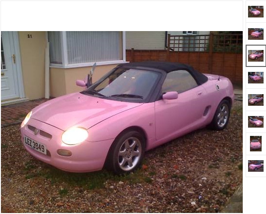 Mgf Pistonheads Taste - The image shows a unique, pink sports car parked on a driveway with a paved surface. The car features alloys, glossy paint, and a convertible top that is down in the current photo. The vehicle is equipped with two side mirrors and has a distinctive design that sets it apart from more common cars. The colour and vivid detailing suggest that the car may have a custom or special edition design.