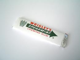 Pistonheads - The image shows a package of Wrigley's Spearmint chewing gum. The gum is white, and the package is predominantly green. The package also features the recognizable Wrigley's red and white logo. The Wrigley's brand is visible along with the flavor, which is spearmint. The package looks like a typical piece of chewing gum ready for purchase.