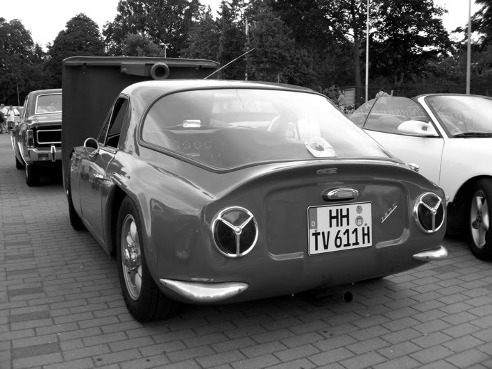 Early TVR Pictures - Page 10 - Classics - PistonHeads - In the center of the image, a classic beetle car, painted in a vibrant shade of black, takes the spotlight. The car is positioned on a brick paved street, adding a touch of rustic charm to the scene. Next to the beetle, another classic car painted in white can be seen, its color contrasting with the beetle.

Together, these two classic cars are on display, suggesting an event or auto show. The background is filled with other cars and foliage, indicating that this gathering is held outdoors. The image captures a moment of vintage automobile celebration, where classic designs and colors are the stars of the show.