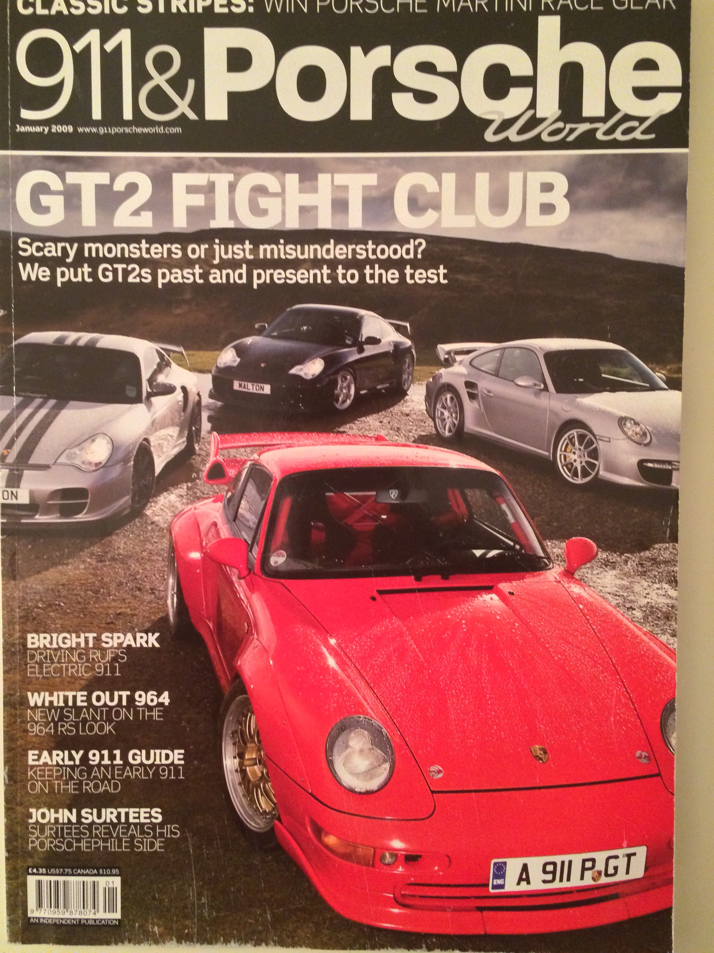 GT2 - Page 70 - Porsche General - PistonHeads - This image appears to be the cover of a "911 & Porsche World" magazine. It features an array of Porsche cars, including a prominent red Porsche at the bottom, suggesting it might be a review or feature on this car. The magazine's title is displayed at the top in large, bold letters, and there is a tagline or a caption just below the title. The display style suggests a glossy or polished publication, likely focused on automotive enthusiasts and news.