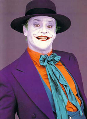 Oh no... What have they gone and done?? - Page 1 - Aston Martin - PistonHeads - The image features a man dressed as the Joker from the popular comic book series. He is wearing a striking purple suit with an orange button-up shirt, which is a signature look of the Joker. The man has accessorized with a blue tie, a hat, and a wide, exaggerated grin, embodying the character's chaotic and anarchic nature. His pose suggests confidence and playfulness, typical of the Joker's character. The colors and elements in the image are vibrant, with bold shades that emphasize the Joker's iconic appearance.