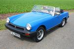 Wanted MG Midget can i get one for about 2k  - Page 1 - MG - PistonHeads - This image features a classic blue convertible car parked on a road. The car has a vibrant shade of blue and has a white top. The single picture focuses on the front of the vehicle, showing the headlights and grill. The car is positioned away from the camera, allowing for a clear view of its design and color. The road on which the car is parked appears to be unpaved, and the surrounding scenery includes grass.