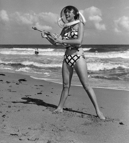 A woman holding a frisbee on a beach