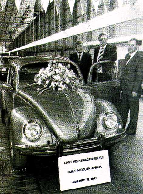 Pistonheads Line Production Classics - This black and white photograph captures a moment from 1979, featuring a vintage Volkswagen Beetle car in the foreground. The car is adorned with a bouquet of flowers on the hood, adding a touch of decorum to the scene. Three men, presumably of significance to the event, are standing next to the car, proudly presenting it to the viewer. They are all dressed formally in suits, hinting at the importance of this occasion. An informational sign placed in front of the car reveals that this car was the last Volkswagen Beetle built in South Africa. The date, January 18, 1979, serves as a historical marker for this milestone in the automobile industry.