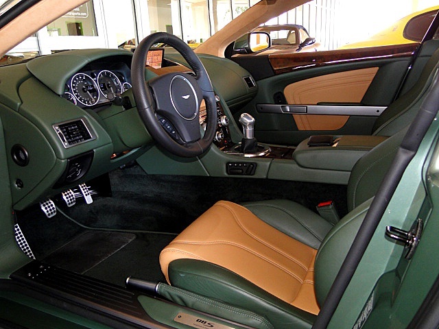 Damn that Tony Hall !! - Page 1 - Aston Martin - PistonHeads - This image features the interior of a luxury car. The driver's side is clearly visible, with the car known for its fine finish. The child seat on the backseat is also highlighted. The interior design suggests a blend of comfort and style. The perspective of the photo implies it might have been taken outside a building, possibly customer service.