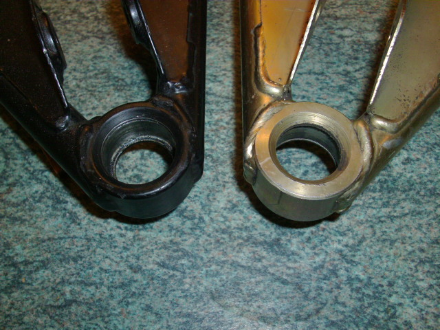 Wishbones Difference Spot Pistonheads - The image shows two metal hinges with a robust black color and silver metallic finish. They are side by side, positioned with one slightly higher than the other, indicating a likely paired installation. The rear of the hinges reveals a deep black hole, and the foreground shows a precarious balance of a hinge leaning on its companion. The background is a nondescript, textured pattern, suggesting a countertop or similar surface. The overall pattern of the surface disruptions the alignment of the hinges, creating an interesting contrast and perspective.