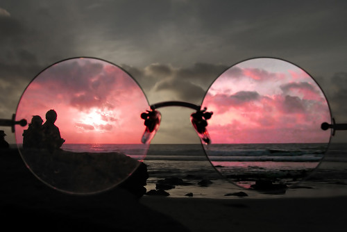 Another old Holden on eBay - anyone needs a estate car? - Page 1 - HSV & Monaro - PistonHeads - The image captures a serene beach scene at dusk. A person is standing on the sandy shore, wearing a pair of distinctive eyeglasses with one lens obstructed by the frame, looking out to the sea. The bright pink hue of the sky serves as a stark contrast to the silhouetted figure, creating a striking visual effect. The other frame lens reflects the scene, adding to the depth and complexity of the image. The overall mood of the image is peaceful and introspective, with the beach and sea providing a tranquil backdrop.