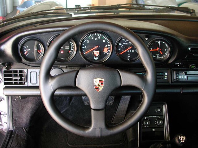 A close up of a black and silver motorcycle - Pistonheads - The image shows an interior view of a car steering wheel area, featuring analog gauges providing information about speed, engine temperature, and other indicators. The wheel is encircled with a logo on the central part, suggesting it's a luxury or performance car. The dashboard and console area are visible, indicating the car's interior. The car appears to be an older model, judging by the design of the instrument cluster and the style of the dashboard.