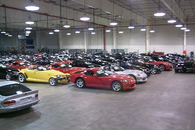 A large group of motorcycles parked in a parking lot - Pistonheads - The image shows an indoor setting, presumably a garage or showroom, where an impressive collection of cars is parked. There are various colors and styles of cars, including sports cars, sedans, and convertibles. They are arranged neatly in rows, and the lighting indicates a well-kept and possibly commercial space. The floor is a concrete surface, and there are multiple large windows and high ceilings, which contribute to the spacious feel of the room.