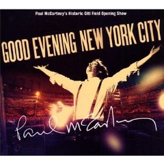 The image features a poster from Paul McCartney's "A Hint of Happiness" tour. The main focus of the poster is a man dressed in a white shirt and suspenders, standing on a stage with a microphone. The stage is lit up with red lights, giving it a warm and dramatic feel. The text on the poster reads "GOOD EVENING NEW YORK CITY" at the top, and "PAUL MCCARTNEY'S HISTORY OF GIIL FIELD OPENING SHOW" at the bottom, indicating that this is a special event for the legendary musician. The overall layout of the poster suggests a sense of excitement and anticipation for the concert.