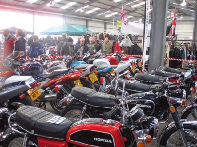 A picture a day....biker banter (Vol 5) - Page 270 - Biker Banter - PistonHeads - The image showcases a vibrant indoor motorcycle show. A multitude of motorcycles, each distinct in color and model, are on display. They are parked neatly side by side, forming an impressive lineup that spans the length of the hall. Some motorcycles have visible registration plates, suggesting they might be for sale or part of a collection. The room is buzzing with people, indicating the popularity of the event. Overall, it's a lively scene filled with the spirit of biking enthusiasts.