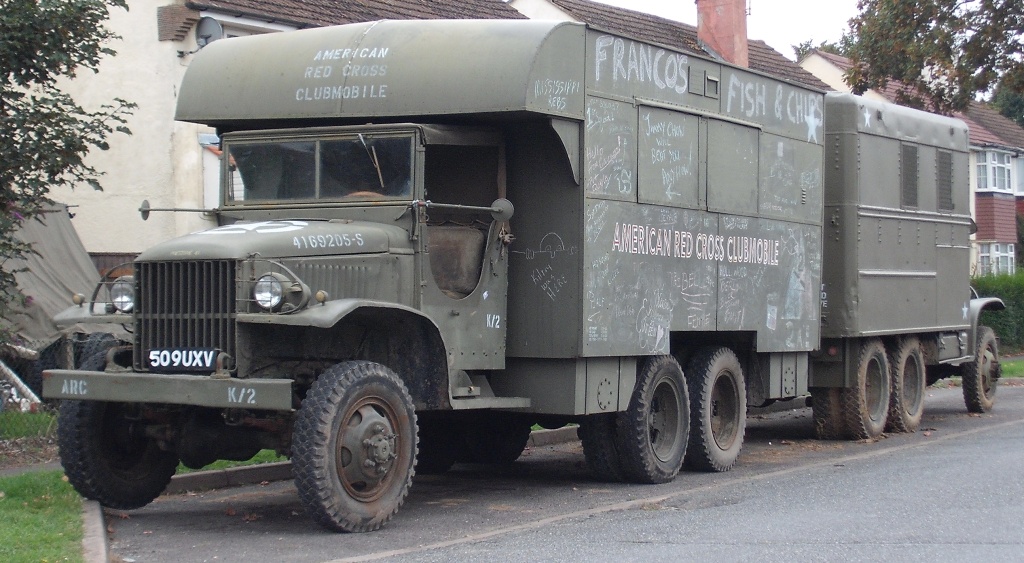 COOL CLASSIC CAR SPOTTERS POST!!! Vol 2 - Page 87 - Classic Cars and Yesterday's Heroes - PistonHeads - The image features an old military-style truck parked on the street. This vehicle, labeled with the words American Red Cross and painted with a simple "FRANK" marking, is a flat-faced truck from the 1950s era. Its military green color, rubber tires, and the graffiti decorating it suggest it has been well-used and is no longer in service. The truck is parked in front of a curb, in front of a house, adding a domestic scene juxtaposed with the industrial, military-fashioned vehicle.