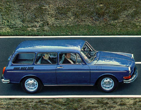 Estates - are they now cool?  - Page 2 - General Gassing - PistonHeads - The image depicts a tranquil rural setting with a bright blue vintage car in the foreground. The car is speeding along a paved road that cuts through a verdant landscape, indicating motion. The vehicle's rear window reflects the faces of the two occupants, a man and a woman both dressed in formal attire. The car's shiny surface reflects light, emphasizing its vibrant color and polished exterior. The eerie duplication of the car and the road in the background adds a surreal quality to the image.