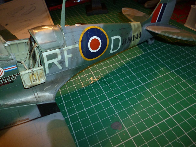 Fairground Ride Build thread - Page 1 - Scale Models - PistonHeads - In the image, a model fighter plane adorned with a camouflage pattern is resting on a green and white grid paper. The plane proudly displays the Royal Airforce (RAF) logo along with the paint number DM II 4441 on its side. The plane's engine is visible on the left side, adding to its realistic details. This scene captures a moment on a workbench, suggesting a model hobbyist's workshop.