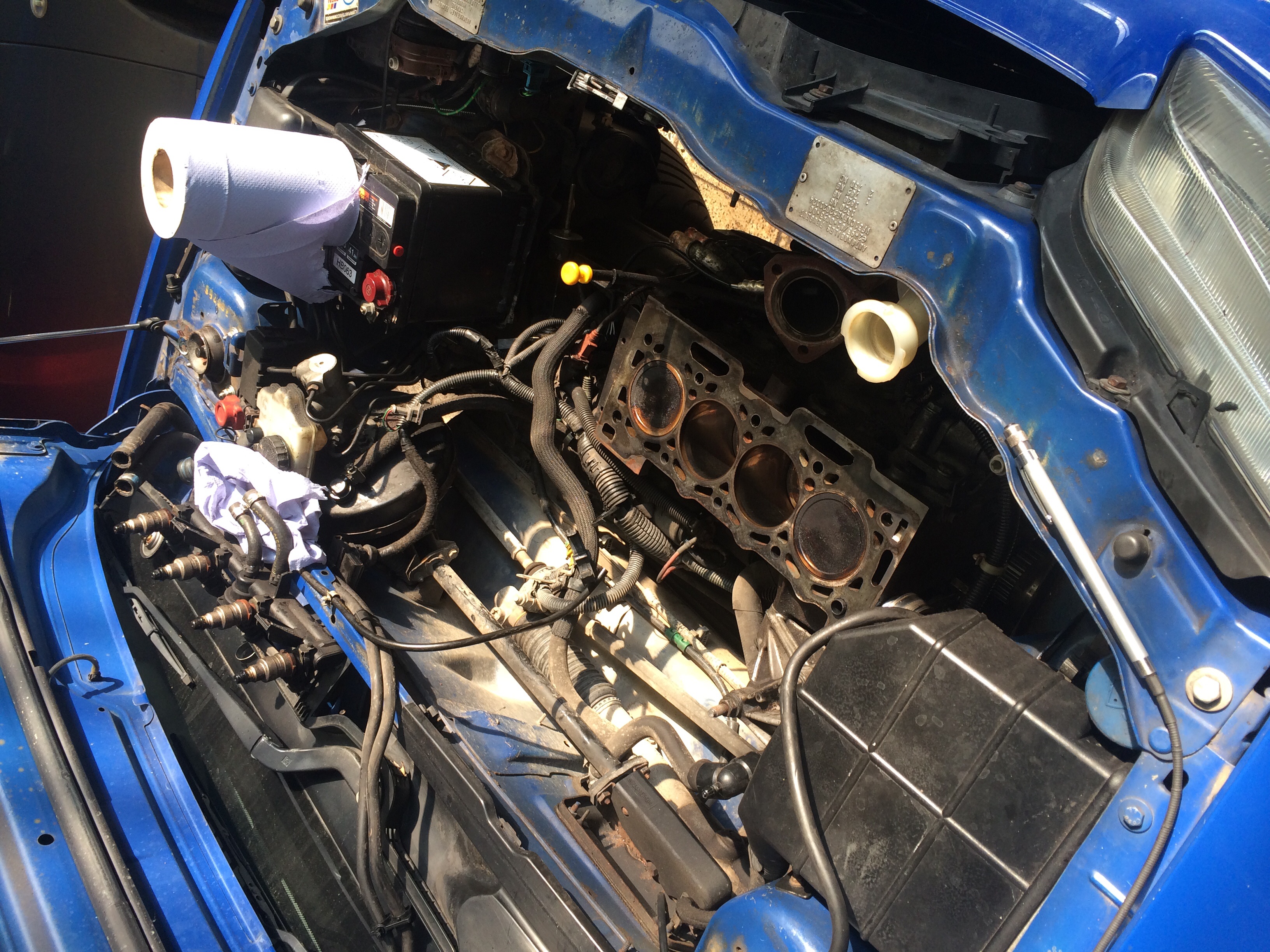 over heating at motorway speeds HELP  - Page 3 - Engines & Drivetrain - PistonHeads - In the image, we see the complex engine bay of a vehicle, touched by blue fabric, signaling potential DIY work. The car itself is making an appearance, painted in a sleek blue color. Underhood, a myriad of black hoses and wires, accompanied by various car parts, create a somewhat congested yet intriguing mechanical landscape. Above the neatly arranged components, a lived-in hose provides a hint of use, adding a touch of realism to the image.