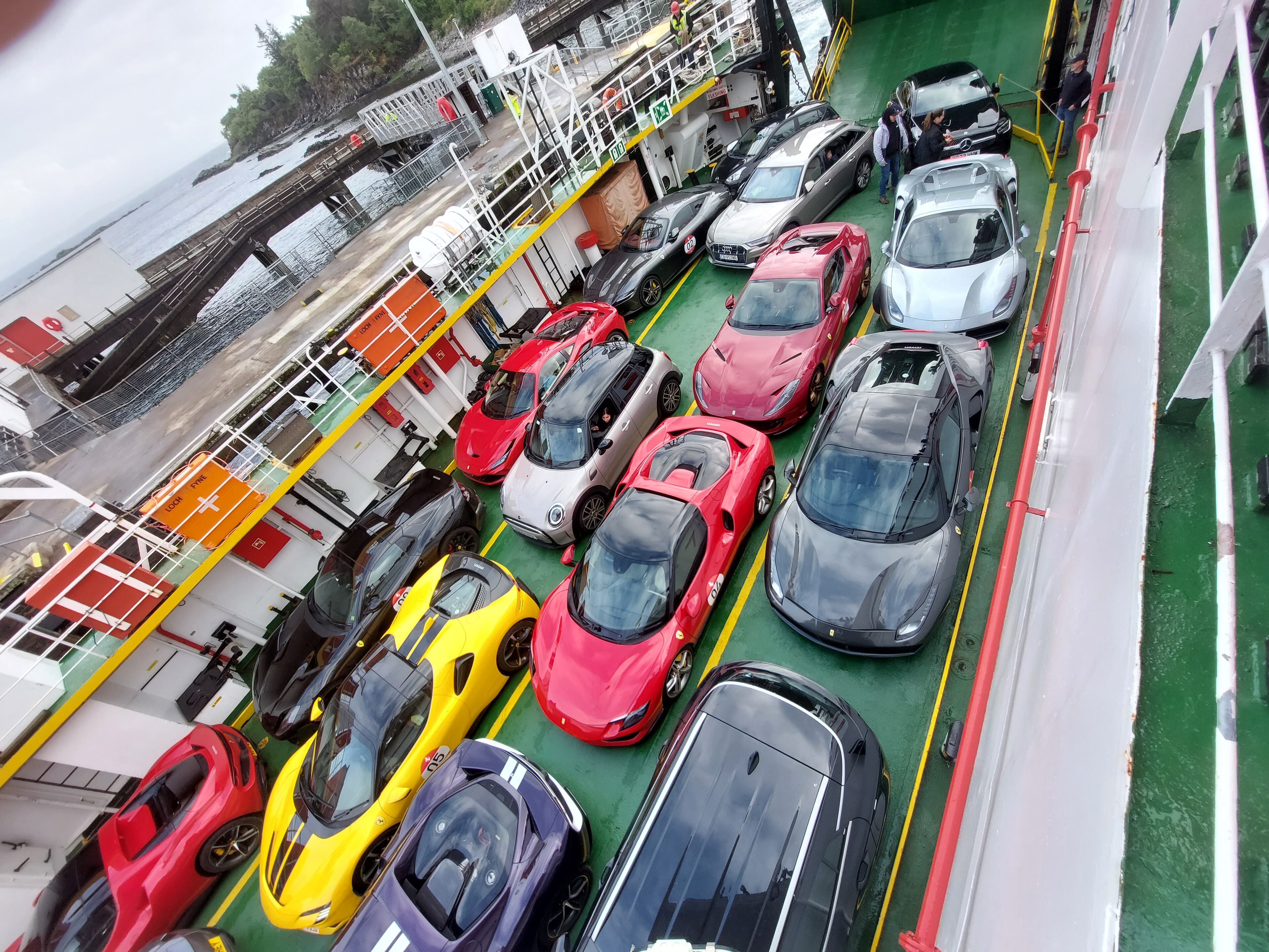 Pistonheads - The image showcases a large parking lot filled with various luxury cars. These cars are parked neatly, each in its own designated space. There's an array of colors and models, reflecting the diverse preferences of their owners. The setting appears to be near a body of water or a marina, as suggested by the presence of boats in the background. A ship with several levels is also visible, adding to the nautical ambiance of the scene.