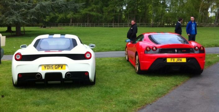 A ''Speciale'' long wait but worth it.  - Page 3 - Ferrari V8 - PistonHeads - The image captures a serene outdoor scene, featuring two unique sports cars parked on a path in a park-like setting. One car is a striking combination of white and black with the number plates reading "Y25GPY". The other car is predominantly red, showcasing a sleek design with the tag "FJRK". In the background, there's a bench and trees, further enhancing the peaceful ambiance.