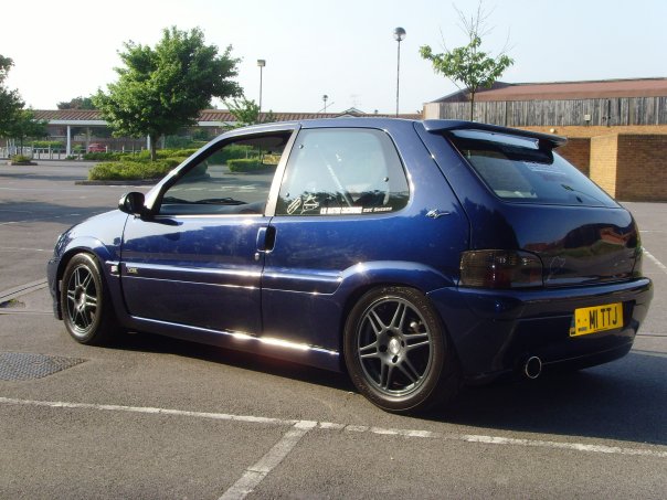 Pistonheads - The photo showcases a sporty blue hatchback car parked in a lot. The vehicle is positioned on the right side of the frame, and its polished wheels shine under the light. The car features a spoiler on the trunk, adding to its sporty appeal. In the background, there are buildings and trees, indicating that the parking lot is located in a commercial or residential area. The sky above is blue, suggesting that it might be a clear day. The image captures a moment of tranquility amidst an otherwise busy environment.