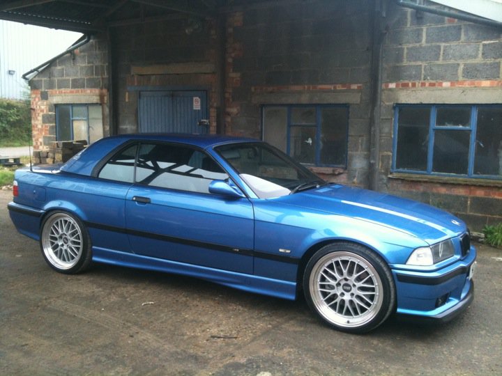 Show Me Your BMW!!!!!!!!! - Page 91 - BMW General - PistonHeads - The image shows a shiny blue BMW car parked indoors, likely in a garage or similar structure. The car has alloy wheels and a sleek, well-maintained appearance. In the background, there are two windows with blue frames and sills, indicating that the vehicle is within a structured indoor space. The ground is made of concrete, and the walls are constructed with brickwork. The lighting is artificial, casting shadows and contrasts on the vehicle and surrounding surfaces.