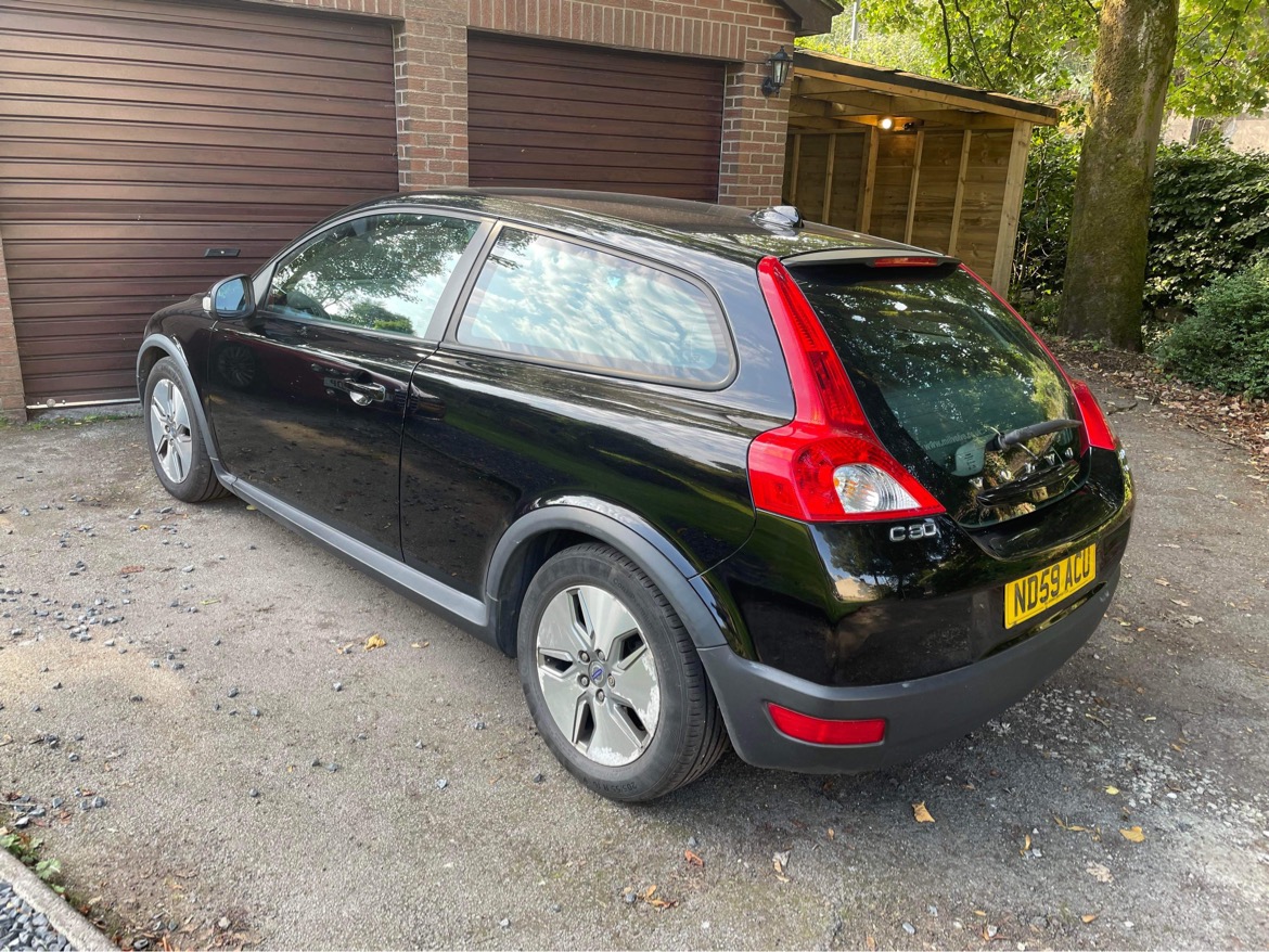 Pistonheads - The image shows a black compact car parked on a driveway. It appears to be a modern hatchback with alloy wheels, and the rear doors have a visible handle. The vehicle's design suggests it might be a newer model or recently maintained. In the background, there is a suburban setting with a garage door partially visible. There are no visible texts or distinctive markings on the car that provide additional information about the make or model of the vehicle.