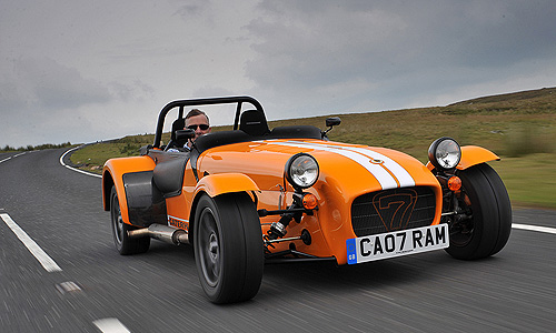 A red and black truck is parked in a lot - Pistonheads - The image features a striking orange sports car in motion, halfway up the side of a road or a hill. The license plate is visible and reads 'CAO7RAM'. The car's sleek and aerodynamic design suggests it is well suited for high speeds, adding to the sense of movement captured in the photograph. The car appears to be a production model, although specific brand or model details are not provided. The photographer seems to have captured the vehicle during a sunset, given the warm glow bathing the car and casting subtle reflections on the polished orange body.