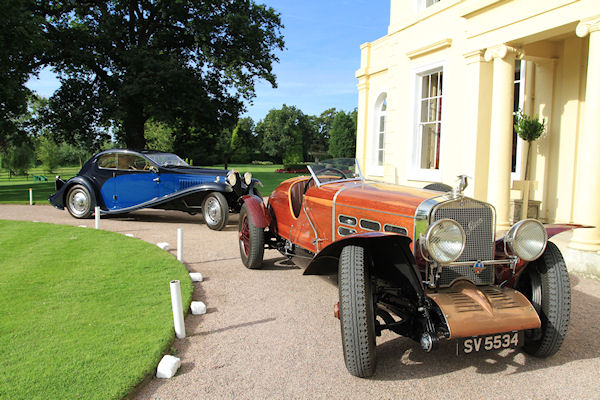 A red truck parked in front of a building - Pistonheads - This image captures a serene moment on a manicured lawn where two vintage cars are parked. The blue car and the orange car, both convertibles, are positioned parallel to each other, their front ends facing the camera. The contrasting colors of the cars against the backdrop of lush green grass and mature trees add a vibrant touch to the scene. The cars appear in excellent condition, indicating that they are likely part of a collection or exhibition. The absence of any people or activity suggests a tranquil setting, possibly during the day, given the bright light illuminating the scene.