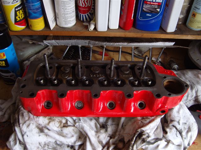 pics - Page 1 - Classic Minis - PistonHeads - The image shows a shop floor setting where a red and black alternator is being worked on. A number of tools are scattered around the machine, including a pipe wrench and a pair of vise grips. The alternator is laid out on a motor oil-stained cloth, suggesting recent maintenance or repair. The workshop gives the impression of an active garage or automotive repair facility.