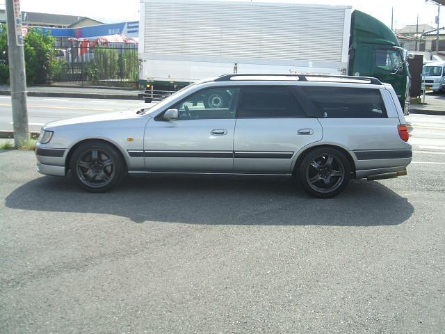 Street Pistonheads Sleeper - The image presents a silver station wagon parked on a paved street. The silver car is positioned on the right side of the street and is marked by a set of four wheels for its all-wheel-drive capability. Although the back part of the car is visible, no individual is standing outside it.

The setting appears to be in an urban area as indicated by the presence of an intersection and several trucks in the background. There's also a sidewalk adjacent to the parked car. 

Two prominent features in the background are a few trucks and a trailer. The trucks seem to be in motion, captured at different points in a photo session. The car appears to be in a stationary condition, possibly waiting at the intersection. The image captures the contrast between the static car and the moving trucks in a snapshot of everyday life in an urban setting.