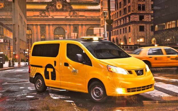 The "new" New York Taxi, fugly or what ? - Page 1 - Yank Motors - PistonHeads - The image showcases a city street scene at dusk. A bright yellow taxi is captured in the foreground, its light reflecting off the wet road surface, enhancing the reflections of city lights. The taxi is prominently positioned, occupying a significant portion of the image, indicating it's the central subject.

In the background, there's a palatial building with a large clock mounted on one of its walls. A lamp post stands near the taxi, and the entire scene is illuminated by the ambient light of the urban setting.

The street itself appears wet, suggesting recent rain, and the road itself is clear, with the exception of a rain-induced puddle that's reflected in the taxi's headlights.

Overall, this image captures a moment of calm and beauty in the midst of the hustle and bustle of city life.