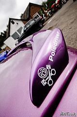 Pistonheads - The image captures a close-up view of the tail end of a vehicle, focusing on the license plate area. The license plate itself is covered, suggesting a temporary or prohibited display. Above the license plate, there's a vividly colored bumper sticker featuring a tool and a wrench, indicating some form of mechanical skill or roadside assistance service. The vehicle is stationary, parked near a building and a few motorcycles, providing a contrasting background for the vehicle's main details.