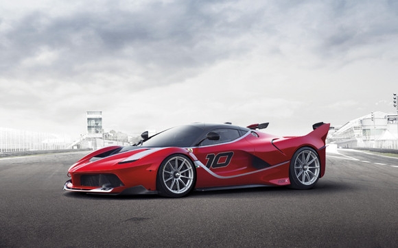 A red and black car with a red umbrella - Pistonheads - The image is a photograph of a red racing car with the number 10 on its flank, positioned on a tarmac road. The car is angled to the right, and the rear wing is lifted, suggesting a speeding motion. The setting appears to be a racetrack or a high-speed road, as suggested by the blurred scenery in the background. The cloudy sky gives an impression of an overcast day. The style of the image is dynamic and vibrant, with an emphasis on the car's speed and design.