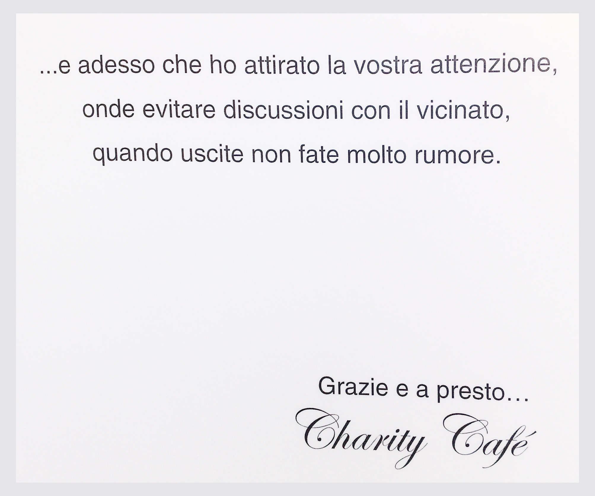 The image is a photograph of a piece of paper textured in a way that suggests it has been creased, indicating it may be in a pocket or a purse. On the right side of the paper, there is a handwritten text in Italian, which reads: "... e adesso che ho attratta la vocstra attenzione, onde evitare discussioni con li vicinato, quadando uscite non fate molto rumore. Grazie e a presto... Charity Cafe" Below this, the graphic design style changes to a more decorative font, where the words "Charity Cafe" are written in a flowing cursive script, with the name connected to the punctuation with a horizontal line, giving it a stylized and elegant appearance. The overall style of the image combines handwritten text with digital graphic design elements.