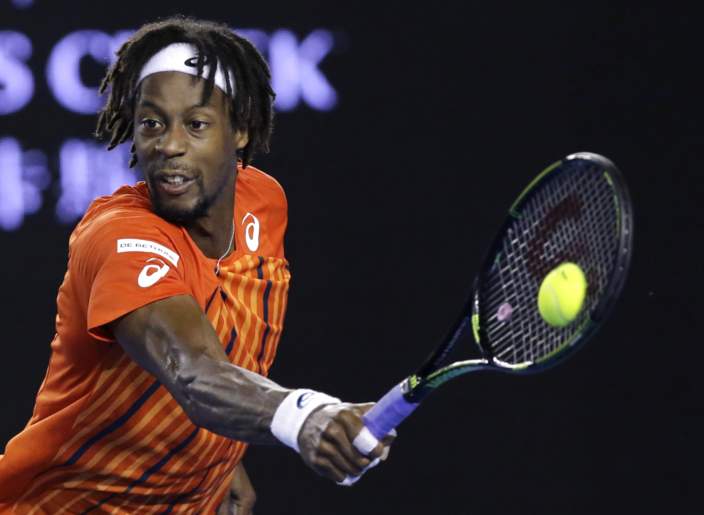 The Tennis Thread - Page 92 - Sports - PistonHeads - The image captures a dynamic moment in a tennis match. A player, dressed in a distinctive orange and red shirt, is in the grip of a powerful swing. His focused gaze is on the ball, broadly situated to the left of the player. In his right hand, he grips a blue tennis racket, which is poised to connect with the yellow ball. The intensity of the action is palpable, with both hands extended outwards, emphasizing the power and precision behind the swing. The sports ball he holds is vibrant and noticeable against the dark background.