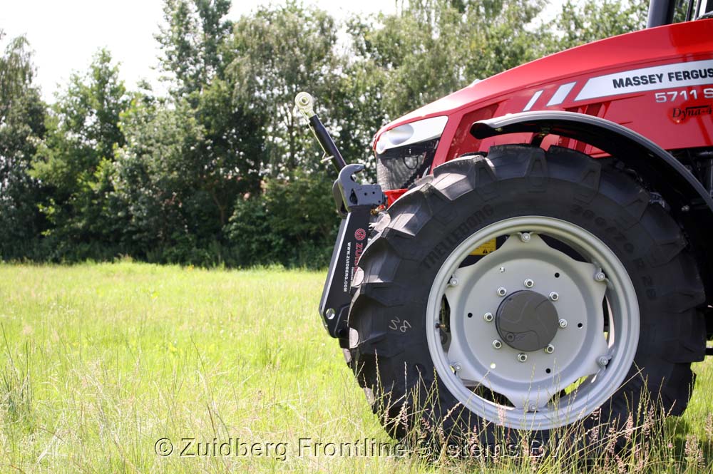 The Numbers Game - Page 306 - The Lounge - PistonHeads - The image showcases a single track tractor branded "Massey" with the model number 5711. The tractor is parked in a grassy field with an expanse of green behind it. The tire of the tractor is large and black, contrasting with the greenery. The side view highlights the angular design of the tractor's fender and the location of the branding.