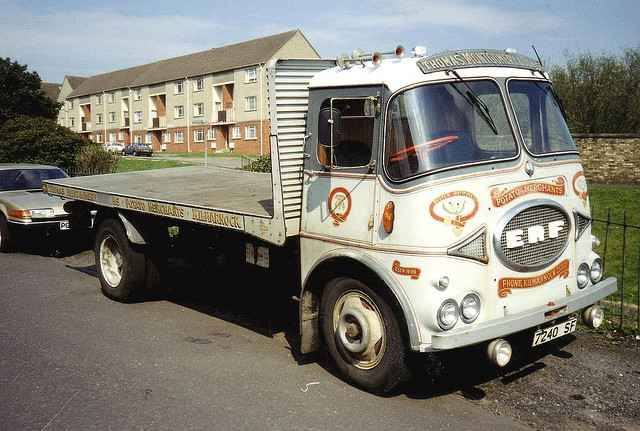 Foden FE or ERF KV? - Page 1 - Commercial Break - PistonHeads - The image depicts a large white commercial truck, possibly a Ben Harrocks ERF vehicle based on its color scheme and logo. The truck is parked next to a curb on the side of a road. Across the street from the truck, there is a single-family home. The scene suggests a residential area, possibly in an urban setting. The image appears to be a photograph taken in daylight.