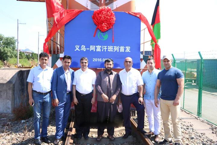 A group of people standing next to a sign