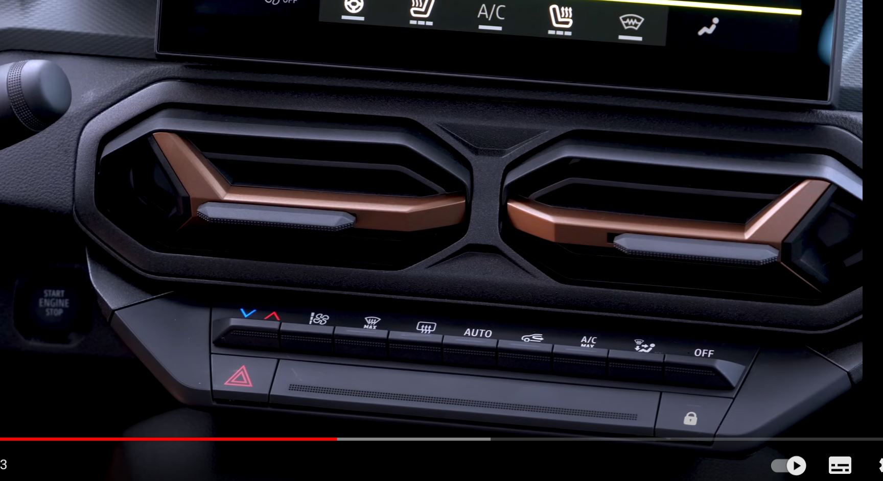 Pistonheads - The image shows a close-up view of the dashboard of a vehicle. It features several control knobs and buttons that are part of the car's infotainment system, which includes a large screen displaying what appears to be a video or a navigation interface. The color scheme of the interior is brown and black, with the dashboard having a textured appearance.