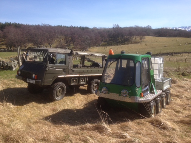 Soft top alterations - Page 1 - Scotland - PistonHeads - The image showcases a pair of vehicles parked on a pastoral field. There's a large, rugged truck and a small, vibrant vehicle with a green and white color scheme. The backdrop of the scene is a serene landscape with modest hills and trees, under a clear sky. The grassy field, where the vehicles are parked, suggests a rural or semi-rural setting. The image gives a sense of openness and tranquility.