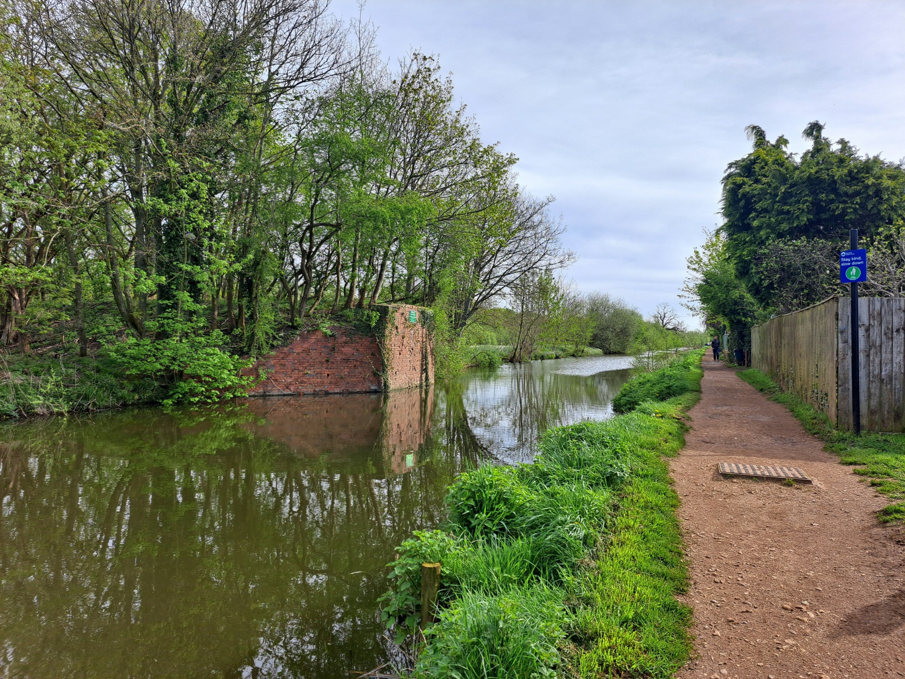 Pistonheads - The image depicts a tranquil outdoor scene. It features a canal or waterway, which is partially bordered by trees and a fence on the right side of the photo. A narrow path runs parallel to the canal, inviting pedestrians for a leisurely walk. The overcast sky casts soft light over the landscape, enhancing the serene atmosphere. The presence of greenery and the calm waterway suggests that this area might be part of a park or a natural reserve. The image does not contain any text or distinguishable brands. The relative position of the objects indicates that the path is situated close to the canal, providing an alternative route for visitors.