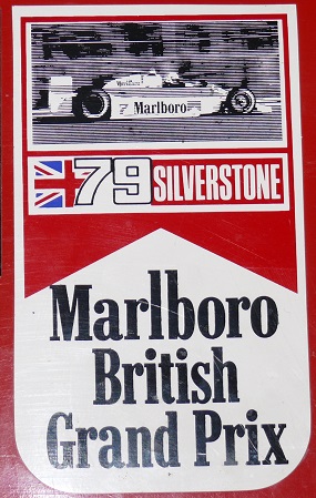 Show Us Your Stickers! - Page 1 - Formula 1 - PistonHeads - This image features a cigarette advertisement, themed around British motorsports. The main focus is a vibrant red backdrop, framed by white borders, depicting a race car. The text on the advertisement promotes Marlboro cigarettes and identifies their sponsorship of the Silverstone Grand Prix, as well as their association with the British racing scene. The advertisement's design is reminiscent of vintage motorsport posters, capturing the excitement and glamour of the sport.