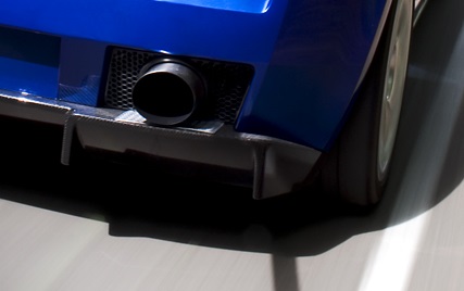 SL Carbon Diffuser on LP560/LP550 - Page 1 - Gallardo/Huracan - PistonHeads - The image showcases the back of a blue car, focusing on its exhaust pipe. The car appears to be in motion, as indicated by the blurred background and the exiting tailpipe. The exhaust pipe and bumper are clearly visible and seem to be in good condition. The vehicle's color provides a striking contrast against the grayscale street, emphasizing its movement.