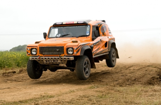 Today I have mostly been driving... - Page 1 - Middle East - PistonHeads - The image shows an orange off-road vehicle in motion on a dirt track. The vehicle is clearly designed for off-road use, given its raised suspension and rugged appearance. The engine cover has the number 43 visible, which could be associated with the make or model of the vehicle or perhaps indicate its power or engine size. The vehicle is positioned slightly to the left, with the wheel contacting the ground at a slight angle, which suggests that it might be navigating a turn or managing uneven terrain. The background is filled with a natural landscape, probably indicating the location might be a rural area or an off-road trail.