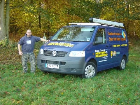 A group of people standing next to a truck - Pistonheads - In the image, a man is standing next to a blue Volkswagen van parked on a lush green field. The van is quite large, appearing to be a service vehicle, possibly used for heating or cooking, given the company name printed on the side that reads "Heat and Cook". The surroundings suggest a serene outdoor setting, possibly a park or a rural area. The man himself is casually dressed in a blue hoodie and camouflage pants, suggesting a relaxed or outdoor-oriented activity. The overall atmosphere of the image is calm and tranquil, with the vibrant green field serving as a picturesque backdrop.